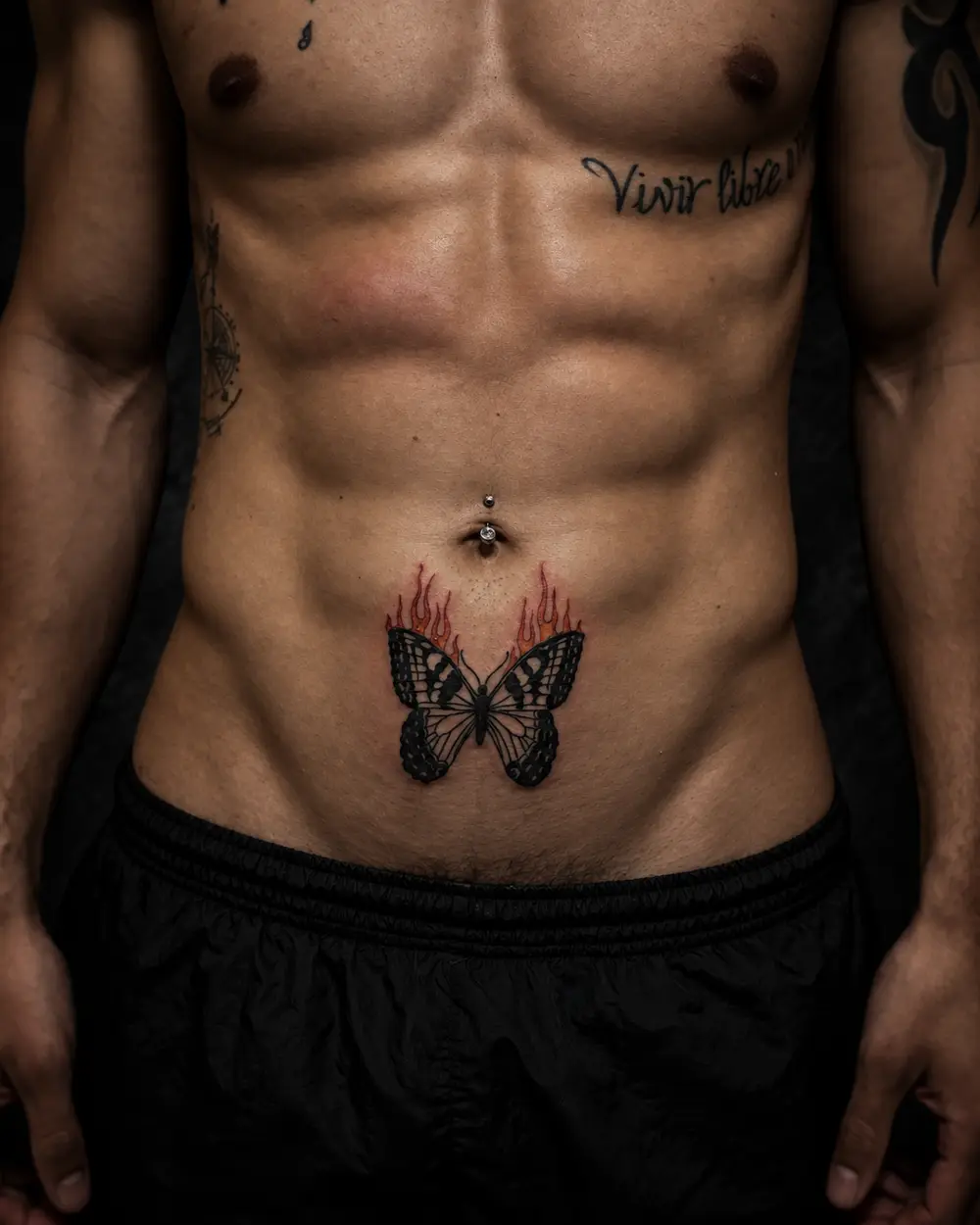 Tatuaje de mariposa con llamas en el abdomen por Lucca Haro, tatuador en Buenos Aires (CABA)