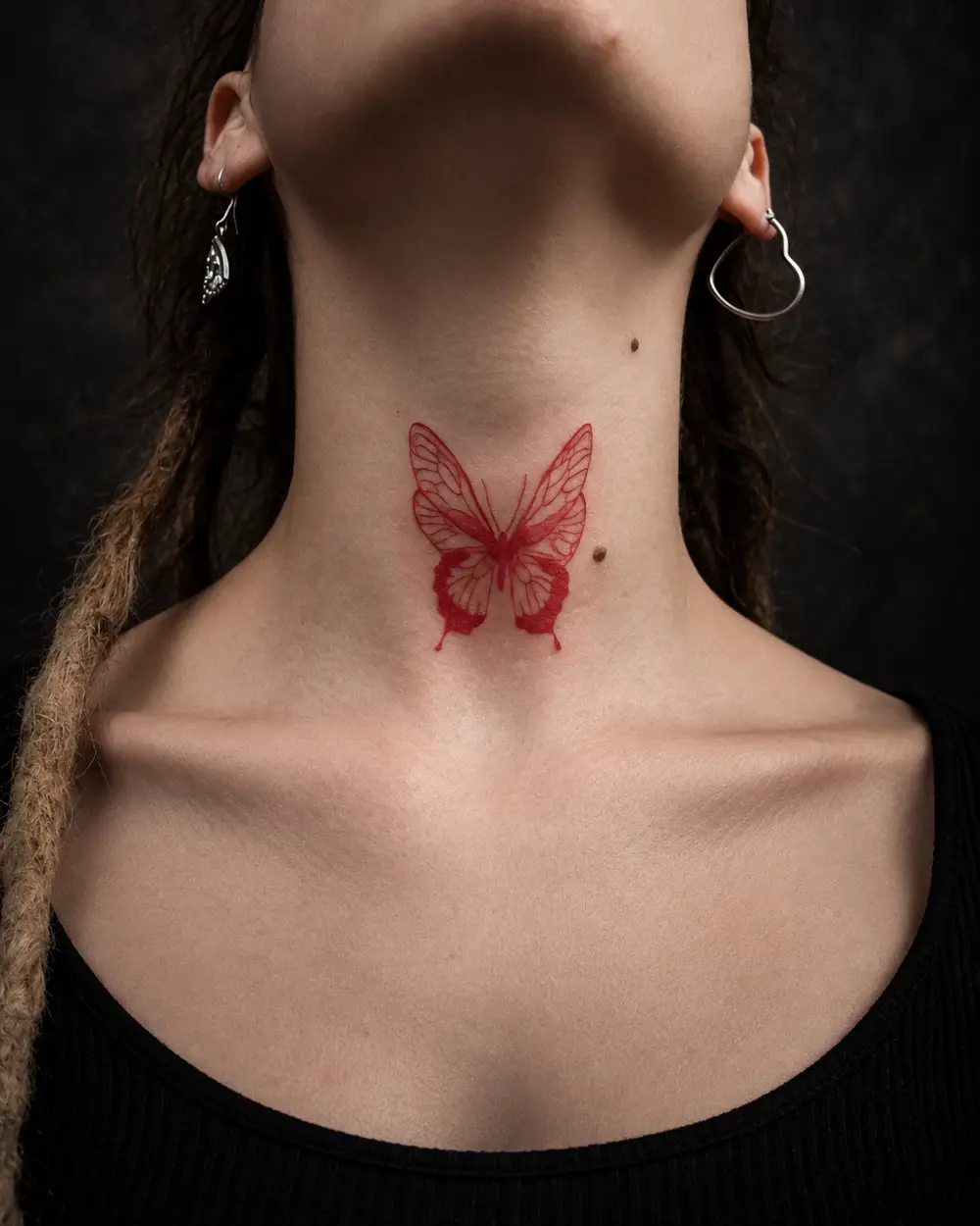 Tatuaje de mariposa roja en el cuello por Lucca Haro, tatuador en Buenos Aires (CABA)
