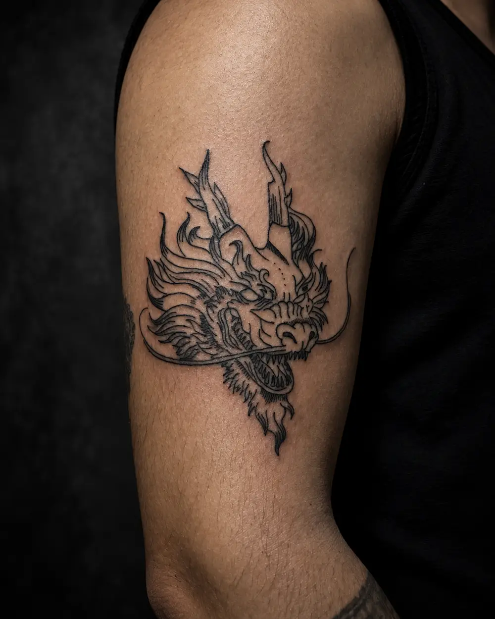 Tatuaje de cabeza de dragón tradicional en el brazo por Lucca Haro, tatuador en Buenos Aires (CABA)