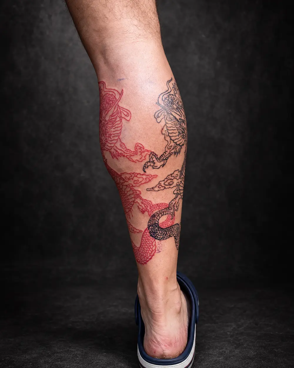 Tatuaje de dos dragones entrelazados en la pierna por Lucca Haro, tatuador en Buenos Aires (CABA)