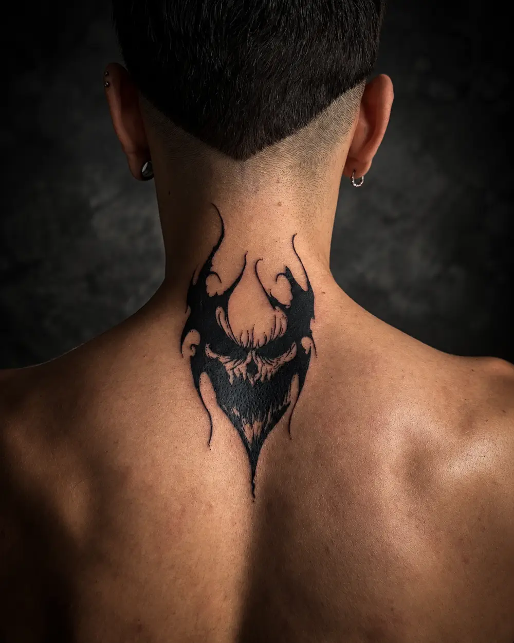 Tatuaje de calavera demoníaca con llamas en la nuca por Lucca Haro, tatuador en Buenos Aires (CABA)