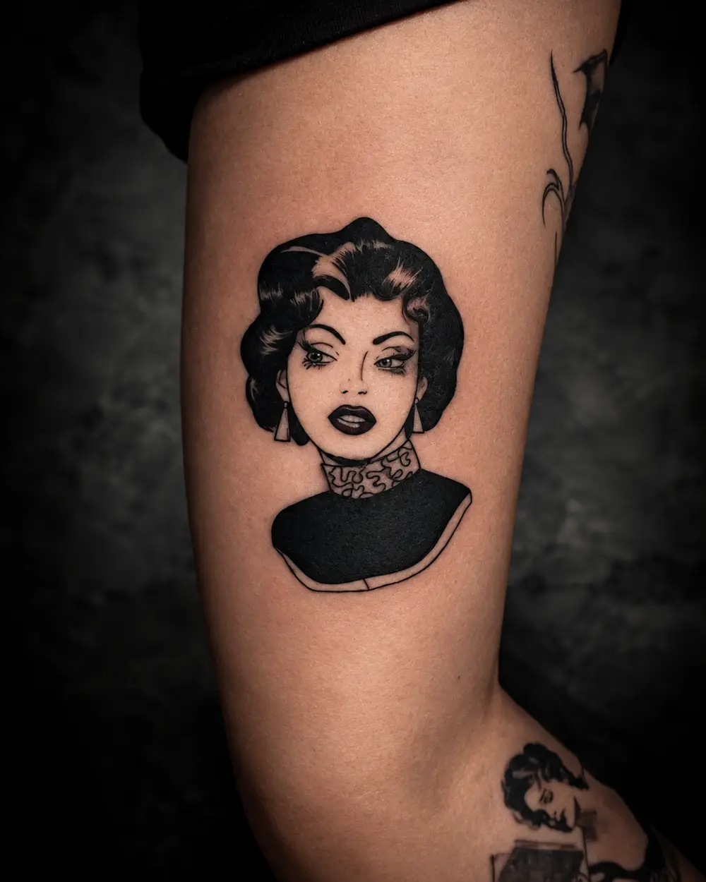 Tatuaje de retrato de mujer estilo cómic en el bíceps por Lucca Haro, tatuador en Buenos Aires (CABA)