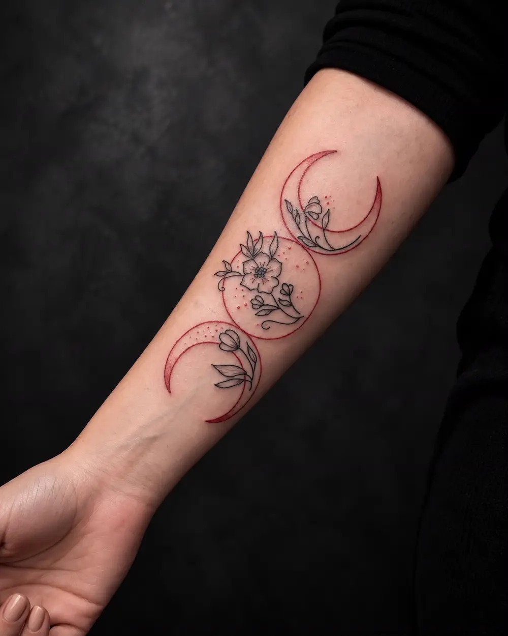 Tatuaje de triple luna con flores en rojo y negro en el antebrazo por Lucca Haro, tatuador en Buenos Aires (CABA)